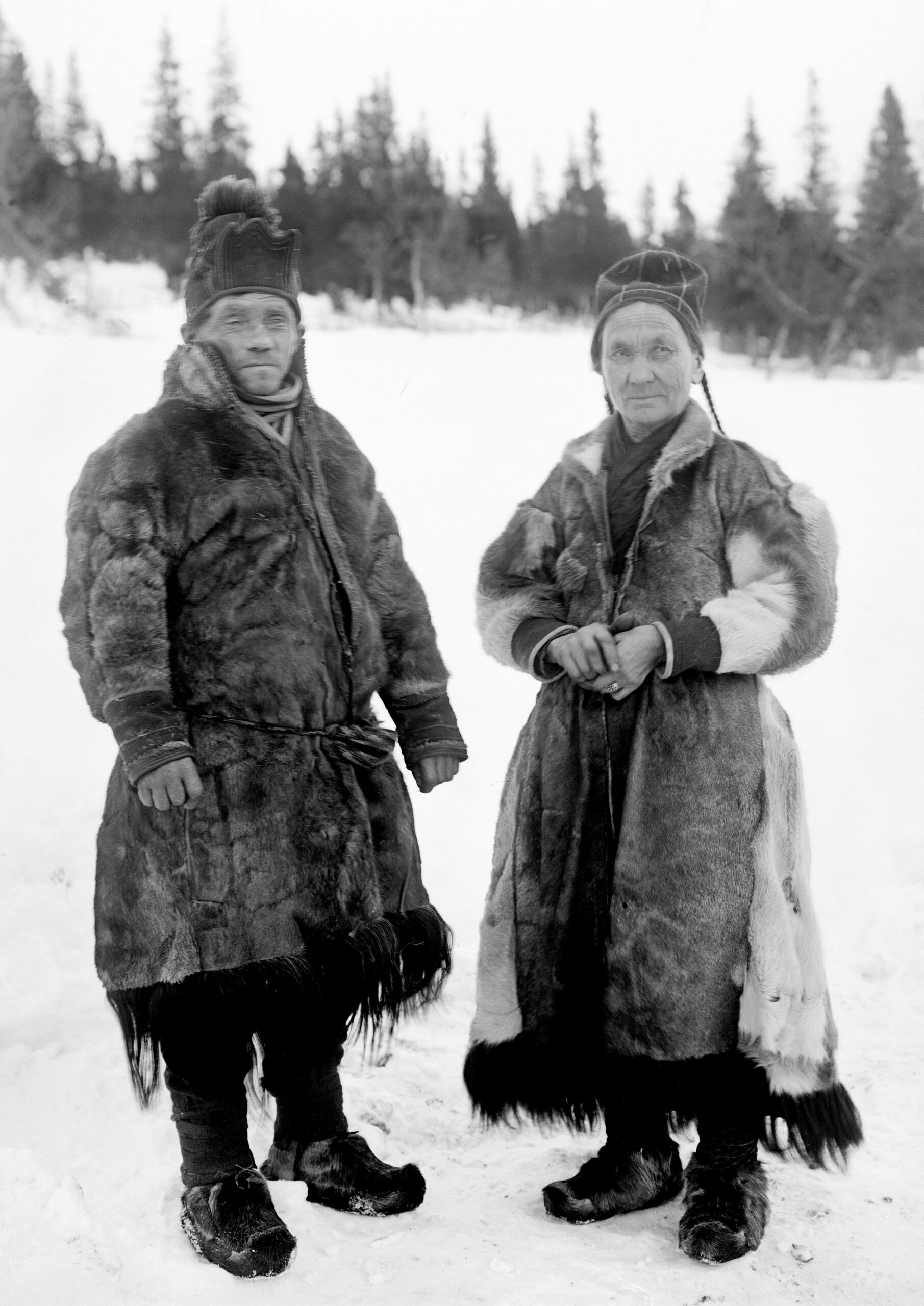 Äldre svartvit bild av Märta Olofsdotter och Nils Nilsson, ett samiskt par i sina renskinnspälsar.