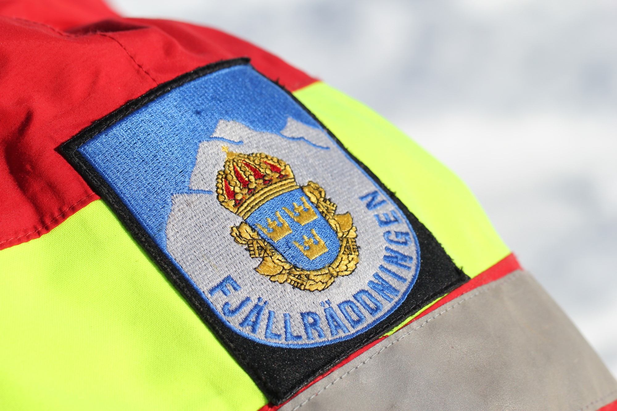 Fjällräddningens logotyp på röd och gul jackärm