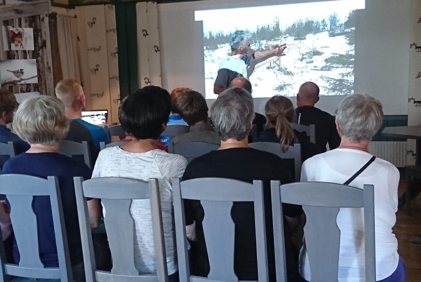 Grupp av människor lyssnar på föredrag inne på naturum