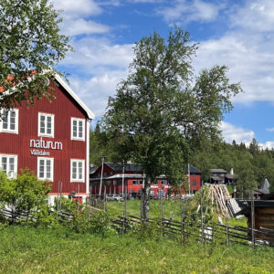 Det röda naturumhuset inbäddat i sommargrönska