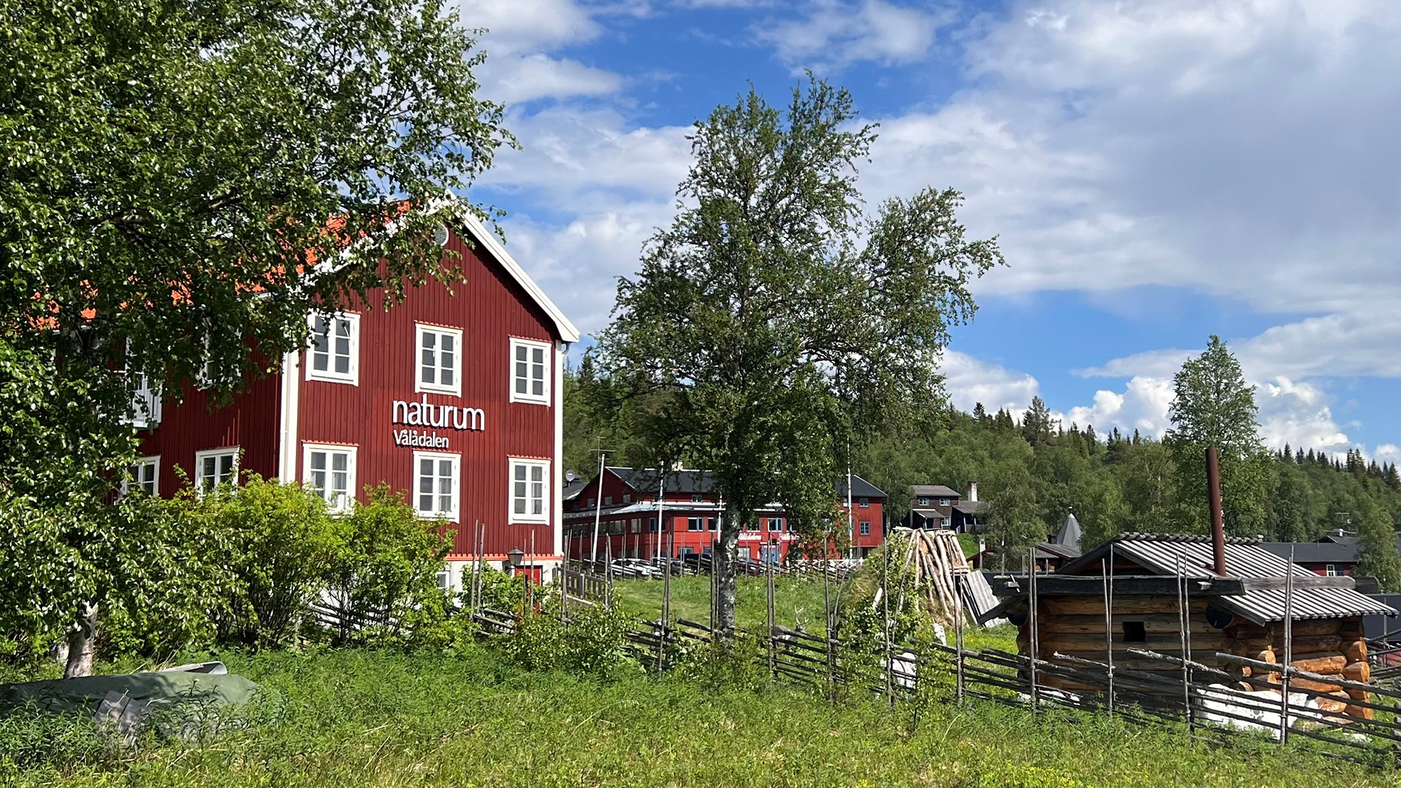 Det röda naturumhuset inbäddat i sommargrönska