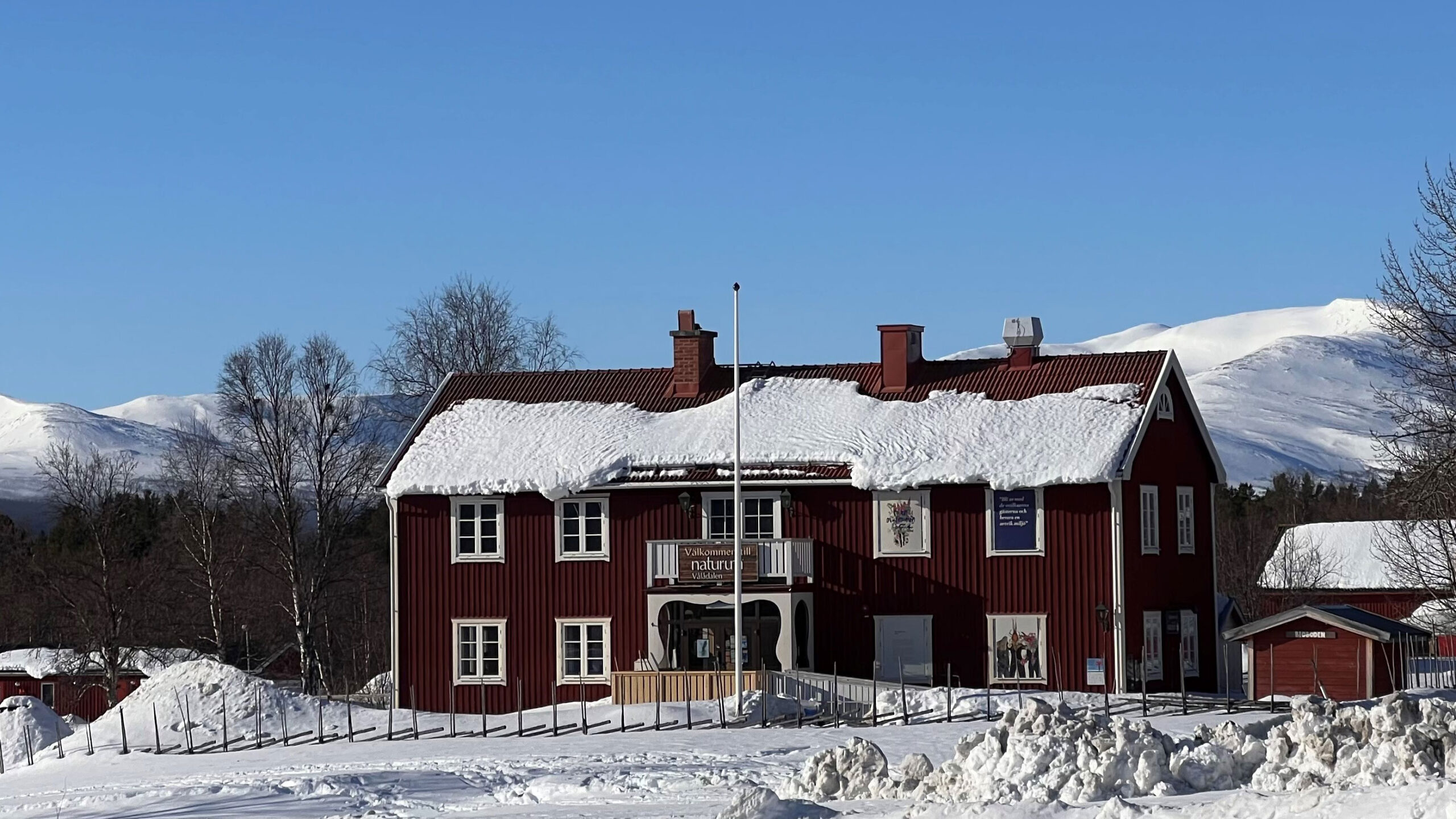 Naturumhuset i Vålådalen med snöklädda fjäll i bakgrunden