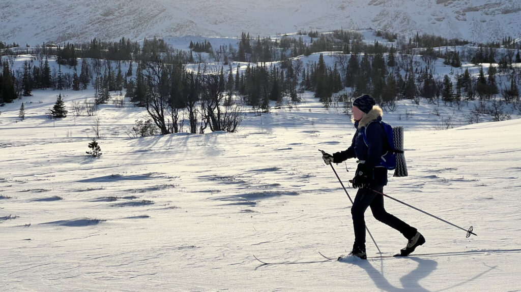 Person som åker turskidor på orörd snö i fjälllandskap